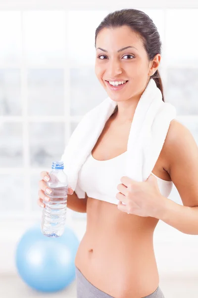 Woman in sports clothing holding a bottle with water