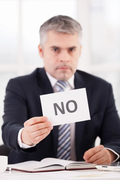 Man in formalwear holding a paper with no sign on