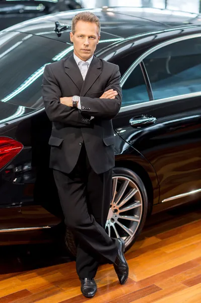 Man in formalwear leaning at the car