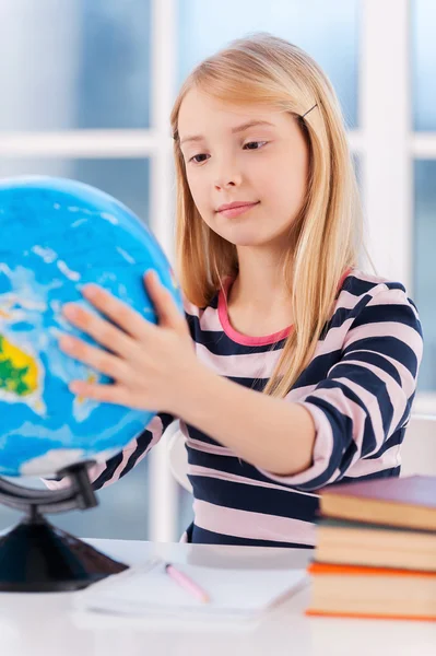 Little girl examining globe