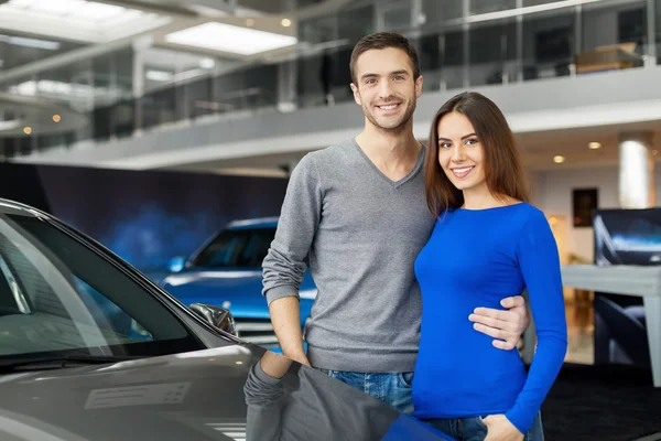 Couple standing near the car at the dealership