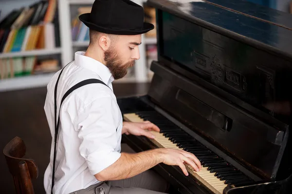 Profile of a bearded men playing piano