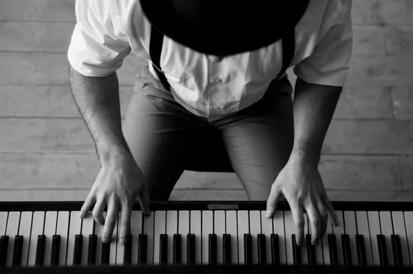 Black and white top view image of man playing piano