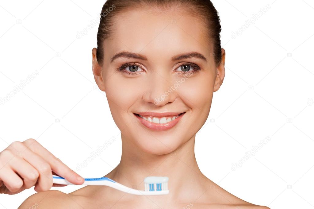 depositphotos_42352437-Woman-holding-toothbrush-with-toothpaste-and-smiling-at-camera.jpg
