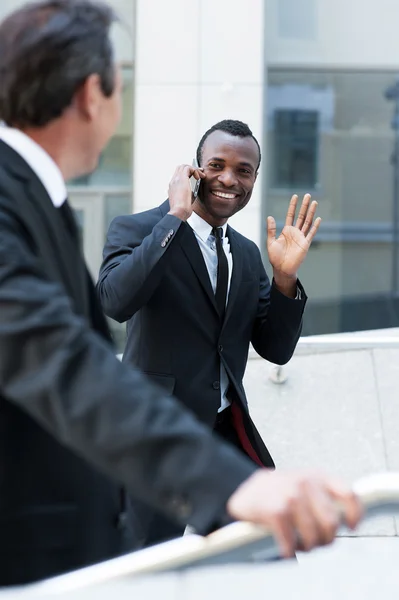 African man waving to his colleague