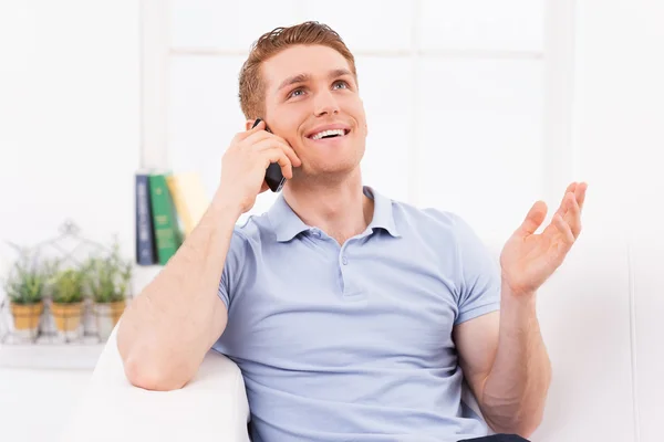 Cheerful young man talking on  phone