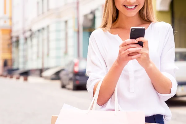 Woman holding shopping bags and mobile phone