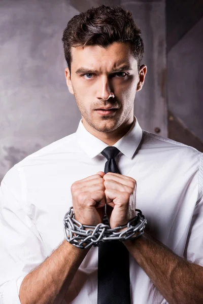 Man in shirt and tie trapped in chains.