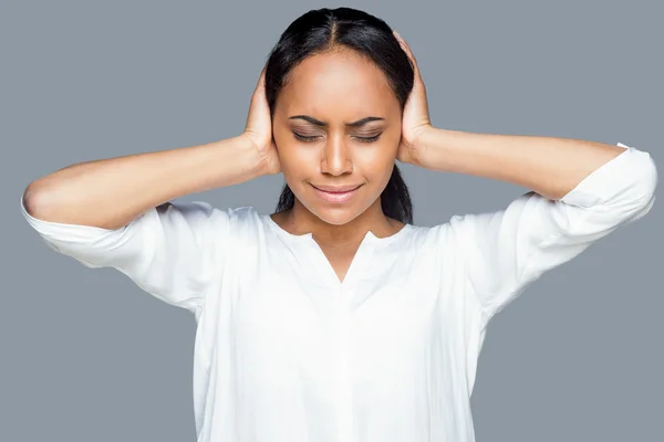 African woman covering ears with hands