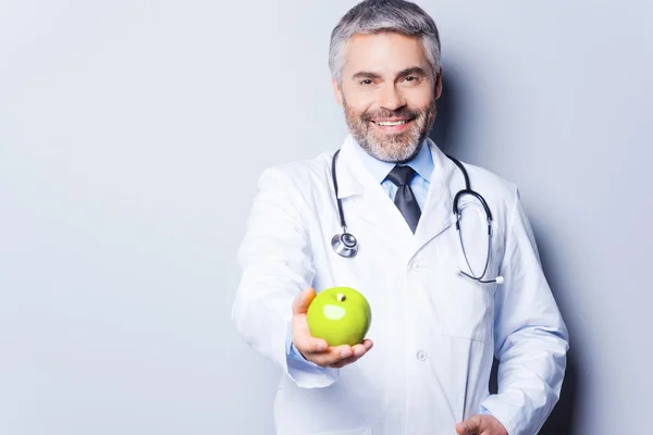 Doctor giving green apple