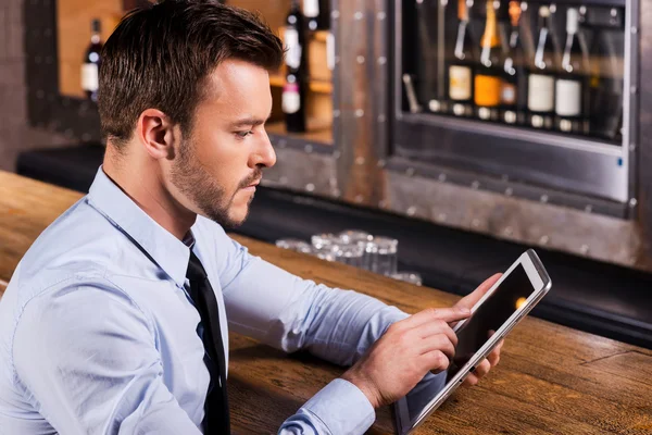 Man in shirt and tie working on digital tablet