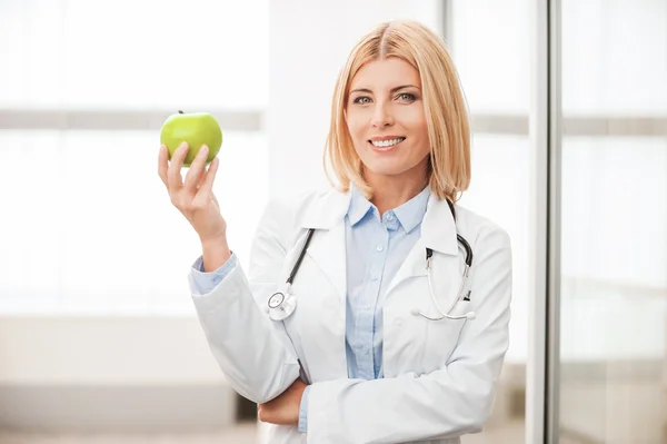 Female doctor holding green apple