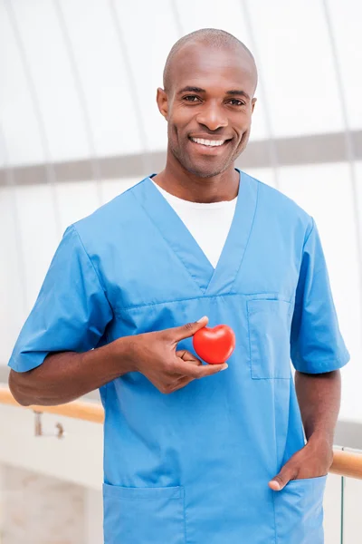 African doctor holding heart prop