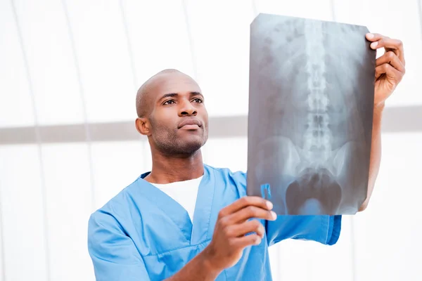 Surgeon examining X-ray image.