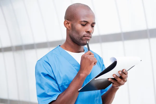 African doctor holding clipboard