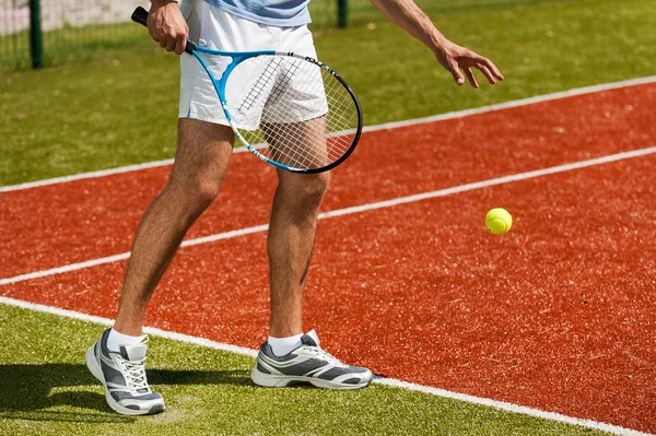 Tennis player preparing to serve ball