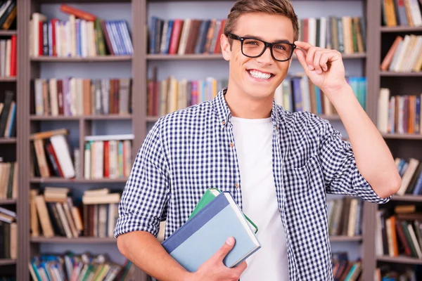 Handsome young man holding books
