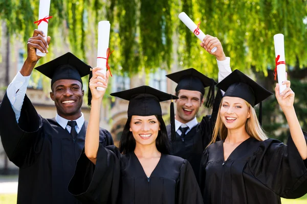 College graduates showing their diplomas