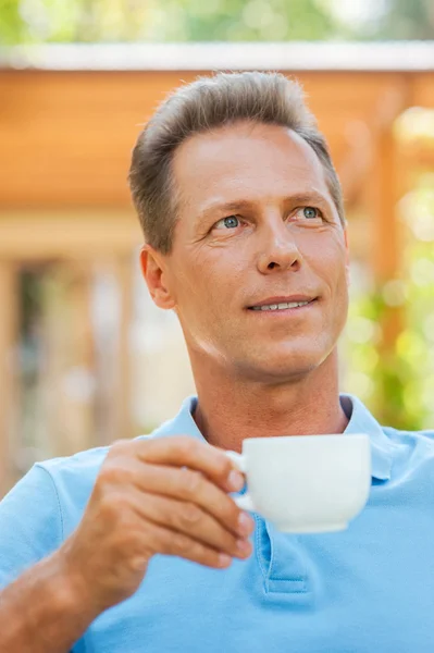 Man drinking coffee and smiling