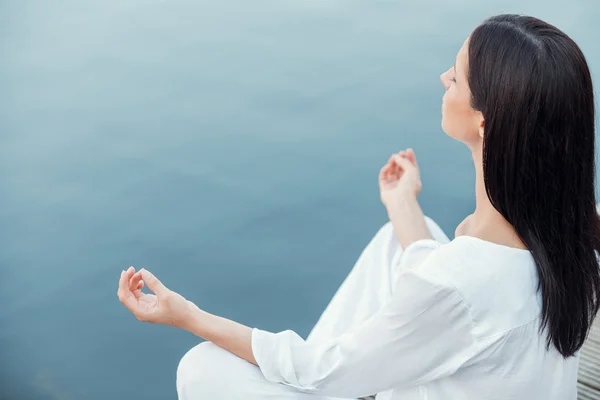 Woman in white clothing meditating