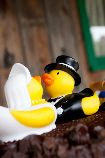 Rubber ducks sitting on the chocolate cake as cake toppers for a wedding ceremony and reception