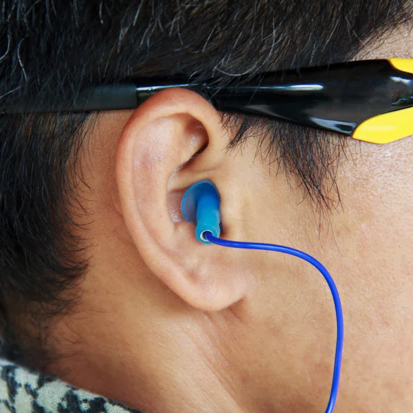 Blue ear plug into the ear.