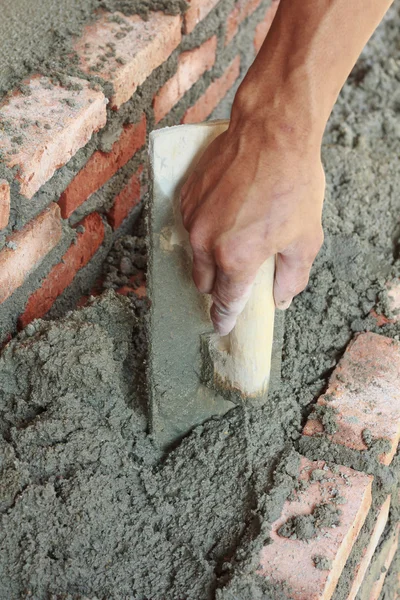 Dirty trowel with glove hand plastering cement mortar in the wal