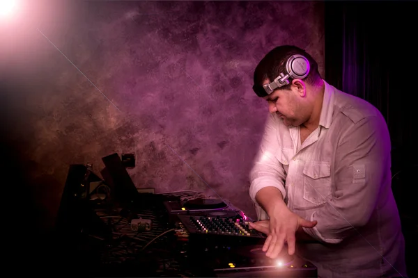 DJ with a mixer equipment to control sound and play music