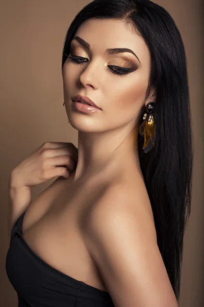 Portrait of beautiful brunette with golden make up