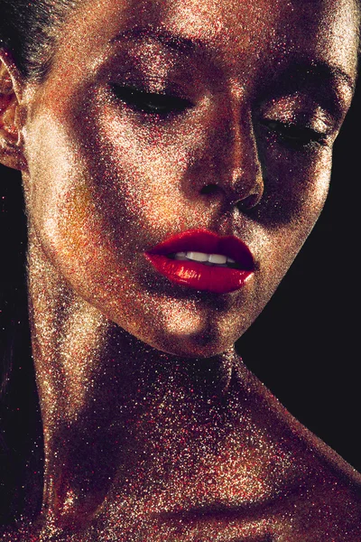 Beautyful girl with gold glitter on her face