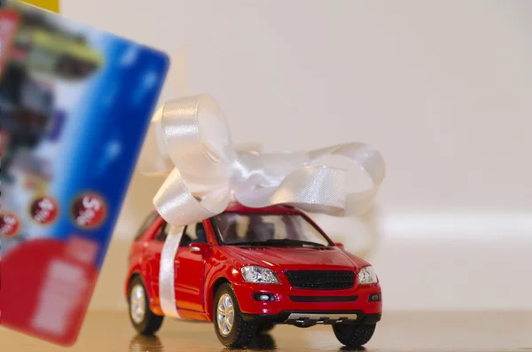 Red machine in a white ribbon and discount card