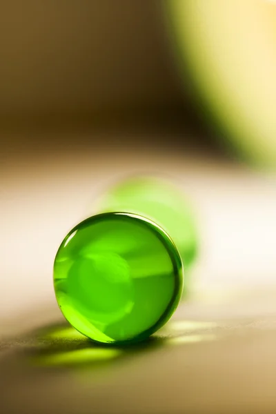 Abstract composition with beautiful, green, round jelly ball on an aluminium foil with reflexion