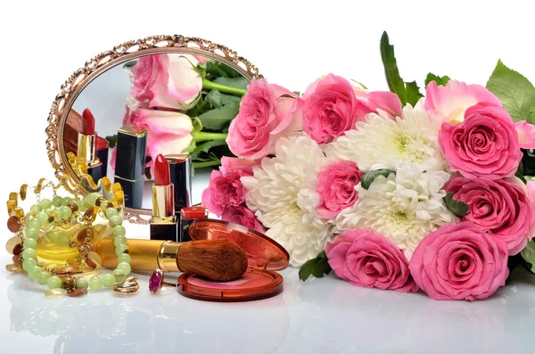 Women's jewelry, perfumes, cosmetics and a bouquet of flowers in still life