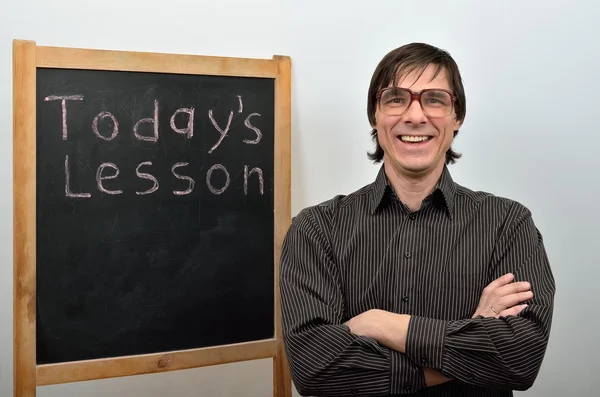 Am a man teacher in glasses smiling near blackboard