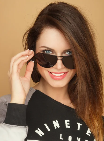 Beautiful smiling girl in a hoodie and sunglasses