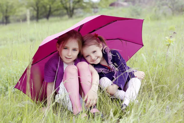 Two little girls under umbrella