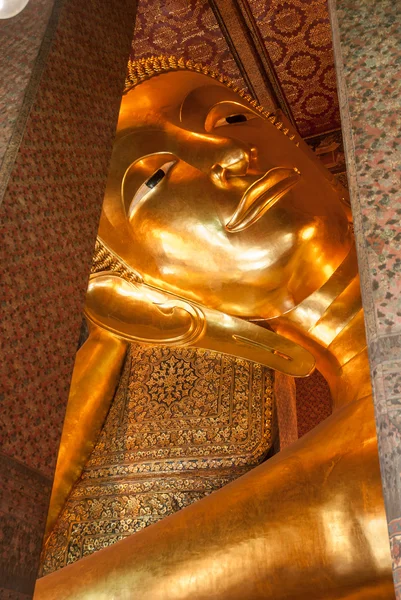 Reclining Buddha gold statue face.