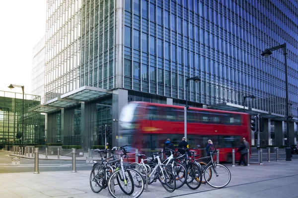 LONDON, UK - MARCH 10, 2014: Canary Wharf business aria. Public transport Famous Red Double Decker Bus and bikes bringing commuters to work