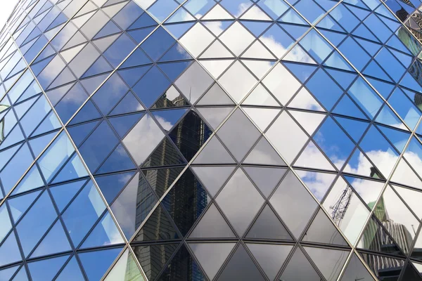 LONDON, UK - APRIL 24, 2014: Gherkin building glass windows texture reflects the sky buildings of the Swiss Re Gherkin, is 180 meters tall, stands in the City of London