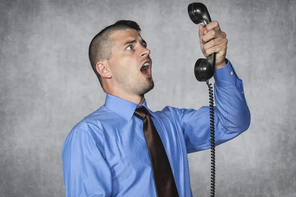 Angry businessman screaming during a telephone conversation