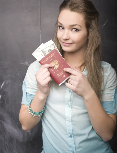 Portrait of cute girl student with money and passport