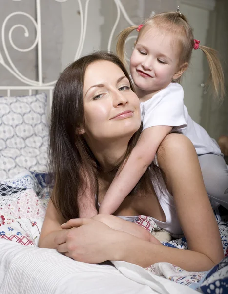 Portrait of happy family, mother and daughter in bed