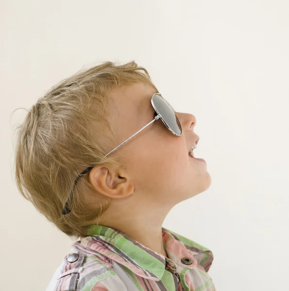 Little boy in sunglasses against white background