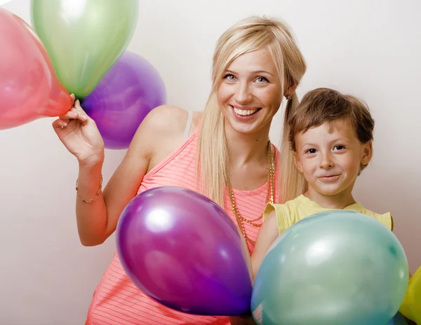 Pretty family with color balloons on white background, blond woman with little boy