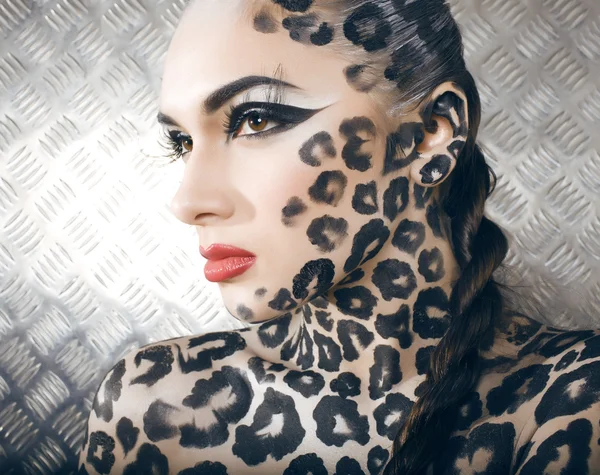 Portrait of beautiful young european model in cat make-up and bodyart