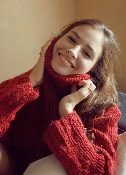 Adorable young woman in sweater at home smiling