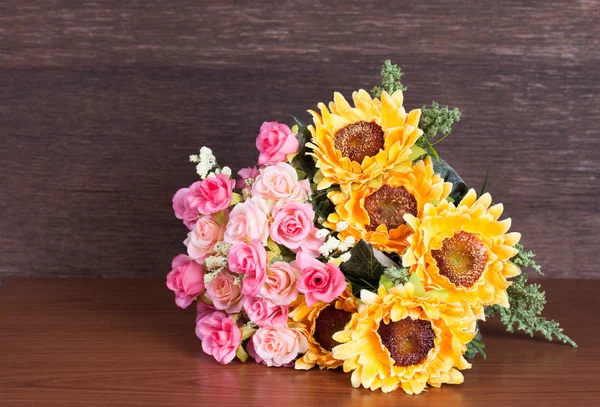 Colorful artificial flower on wood background