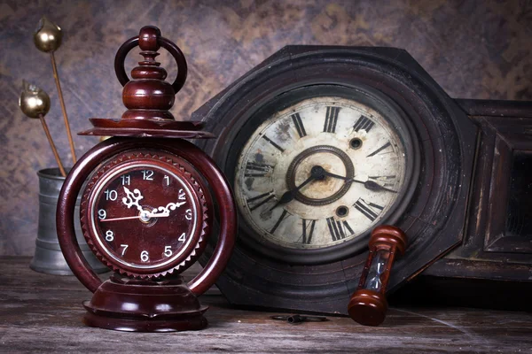 Group of objects on wood table. old clock, hourglass, antique wo