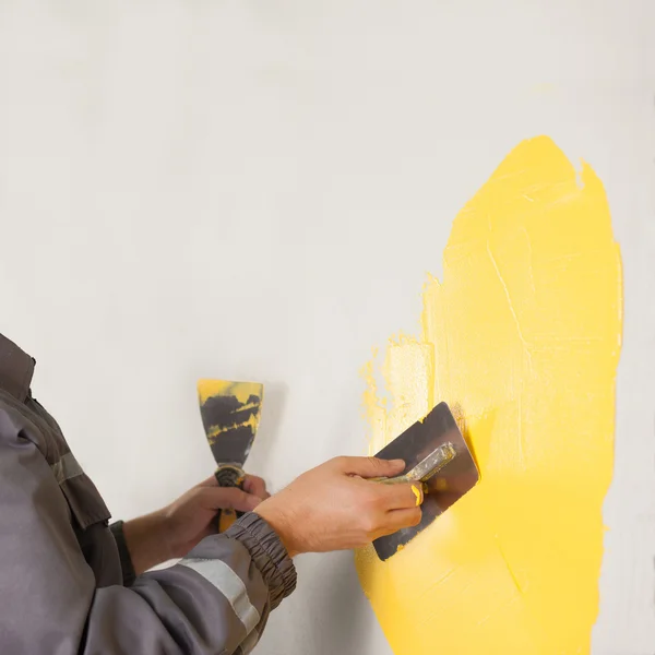 Painting the wall yellow with a paint roller in new house