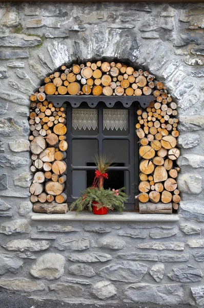 Window in the stone house with woodpile